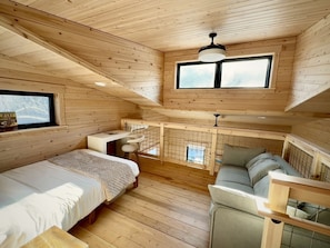 Eine Hütte mit Schlafzimmer auf dem Dachboden, Essbereich und Sitzecke.