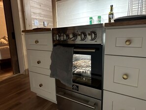 Ett kök med en inbyggd ugn, en bänkskiva i trä och en handduk som hänger över ugnsluckan.