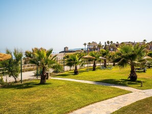 A coastal park with pathways, palm trees, and a distant castle-like structure. - Penthouse with sea view, 6 guests (Casares)