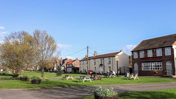 A traditional British pub with outdoor seating, surrounded by residential buildings.