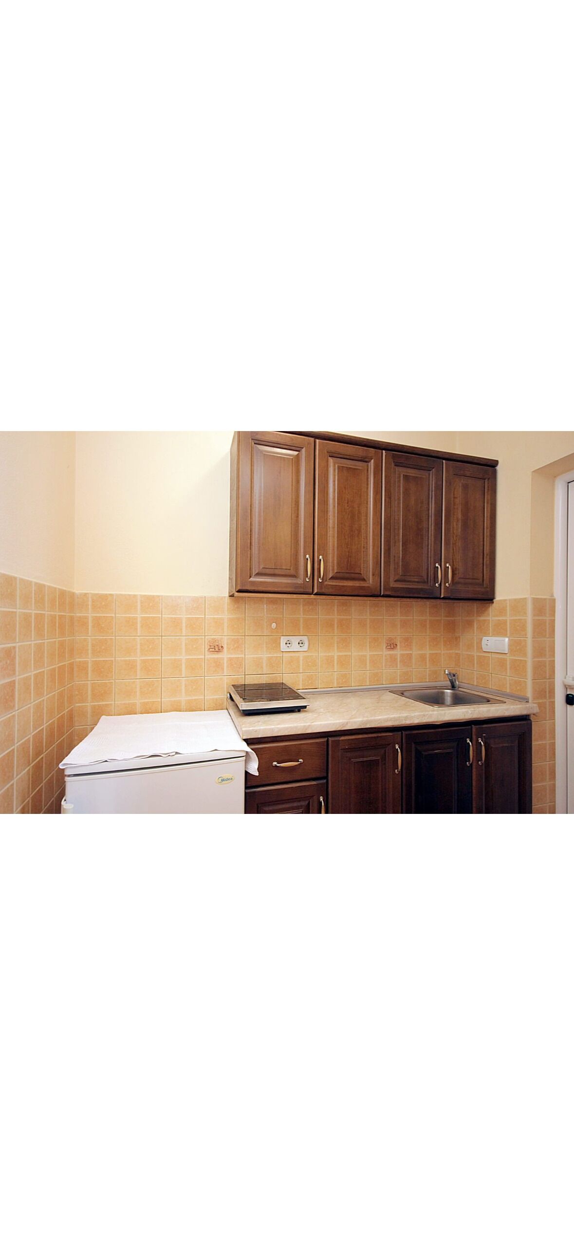 Una cocina con armarios de madera, una encimera y un electrodoméstico blanco.