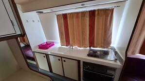 A compact kitchenette with a sink, a window with curtains, a small countertop, and cabinets. - Boat stay by the Mayenne - 9 guests (Chenillé-Changé)
