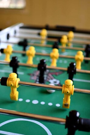 Un gros plan d’un baby-foot avec des figurines jaunes et noires.
