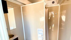 Ein kleines Badezimmer mit Toilette, Waschbecken und Spiegel.