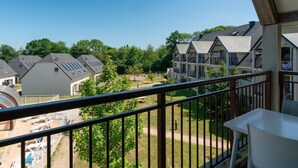 A balcony with a view of residential buildings, a clear sky, and a grassy area. - Normandy Coastal Stay for 4 (Parentis-en-Born)