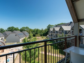 A balcony with a view of residential buildings, a clear sky, and a grassy area. - Normandy Coastal Stay for 4 (Parentis-en-Born)