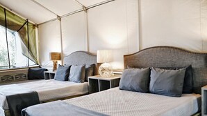 A room with two beds, each with a headboard, bedside tables, and lamps. - Reconnect by the Water: Tented Cabin Oasis for a Texas Lakeside Getaway (Cibolo)
