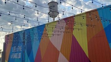 A colorful wall with a geometric pattern and the text 'LIFE IS FINE IN HUMBOLDT.' There are outdoor tables and chairs, and a water tower in the background.