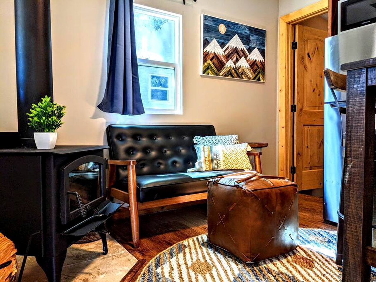 A cozy living room with a sofa, a small table, a fireplace, and a painting on the wall.