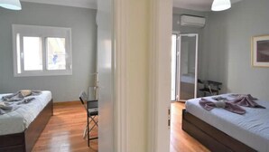 Un dormitorio con una cama, una silla, un escritorio y una ventana.