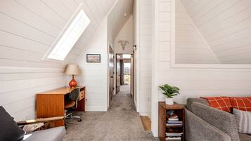 A loft-style room with a desk, chair, and sofa.