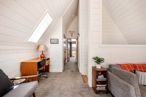 A loft-style room with a desk, chair, and sofa. - Secluded A-frame with Stunning Desert Views in Torrey, Utah (Torrey)