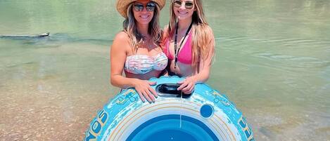 Dos personas sostienen un flotador azul en un día despejado.