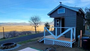 A small cabin with a wooden deck and picnic table in a rural setting. - Tiny House Retreat: Pet-Friendly Haven with Fantastic Lake Views in Henshaw, CA (San Diego Country Estates)