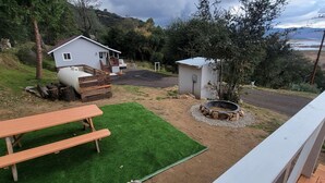 A house with a front porch, a small shed, a fire pit, and a picnic table. - Tiny House Retreat: Pet-Friendly Haven with Fantastic Lake Views in Henshaw, CA (San Diego Country Estates)