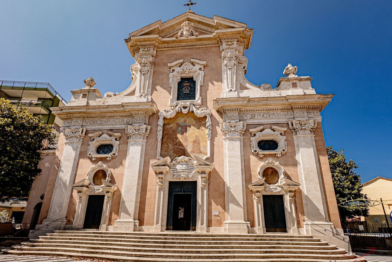 A historic building with ornate architecture, a central entrance, and steps leading up to it.