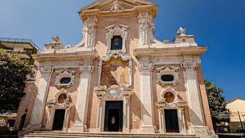 A historic building with ornate architecture, a central entrance, and steps leading up to it.