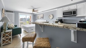 Una cocina moderna con gabinetes blancos, un microondas y una encimera.