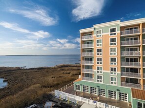 Ein mehrstöckiges Hotel mit Balkonen, Blick auf den Strand und einem Parkplatz.