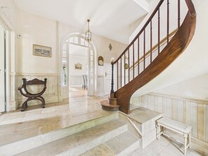 A grand staircase with a wooden handrail and a white bench at the bottom. - House for 13 with swimming pool in Montignac (Montignac)