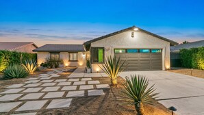 A residential house with a garage, a stone pathway, and a well-lit entrance. - Desert Oasis w/ Pool & Spa, Game Room + Theater (Indio)