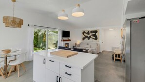 A modern kitchen with a central island, white cabinetry, and pendant lighting. - Desert Oasis w/ Pool & Spa, Game Room + Theater (Indio)