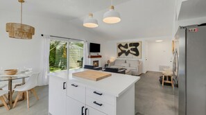 A modern kitchen with a central island, white cabinetry, and pendant lighting. - Desert Oasis w/ Pool & Spa, Game Room + Theater (Indio)