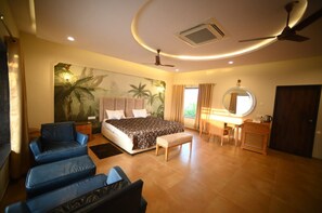 A bedroom with a bed, a desk, a chair, a round mirror, and a ceiling fan. - Dream Habitat Resort (Bhadravathi)