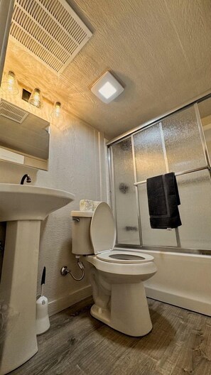 Une salle de bain avec un lavabo, des toilettes et une baignoire.