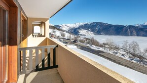 A balcony with a view of snow-covered mountains and a road. - 1BR Apartment Stay for 6 in Doucy (La Léchère)