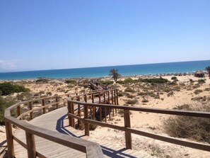 A wooden boardwalk leading to a beach with clear skies. - Casa Helgar in Gran Alacant, Beautiful Sun Set Views & Near attractions (Santa Pola)