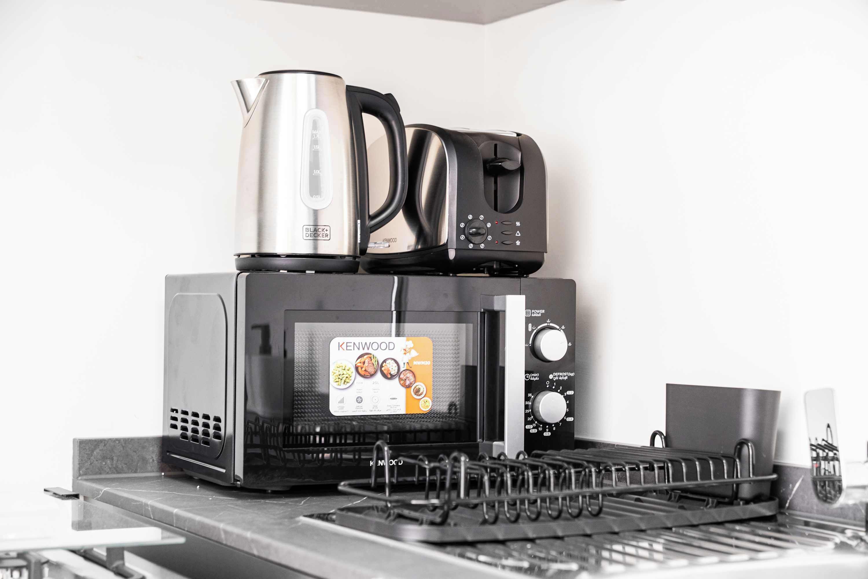 Une cuisine équipée d’un four à micro-ondes Kenwood, d’une bouilloire et d’un grille-pain.