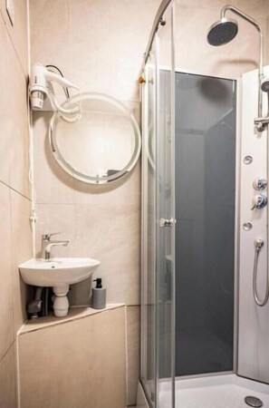 Regadera, secadora de cabello, toallas, papel de baño 