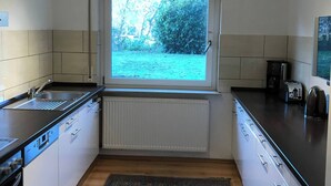 Una cocina moderna con ventana, electrodomésticos integrados y una alfombra estampada.