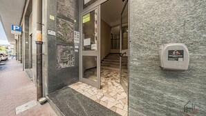 A hotel entrance with a tiled floor, a parking sign, and a here&there branded device.