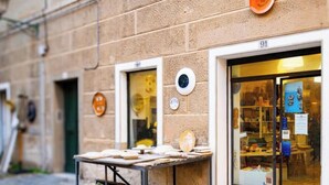 A building with a stone facade, numbered 91, and a storefront with a display of ceramics.