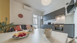 A modern kitchen with grey cabinets, a microwave, and an oven.