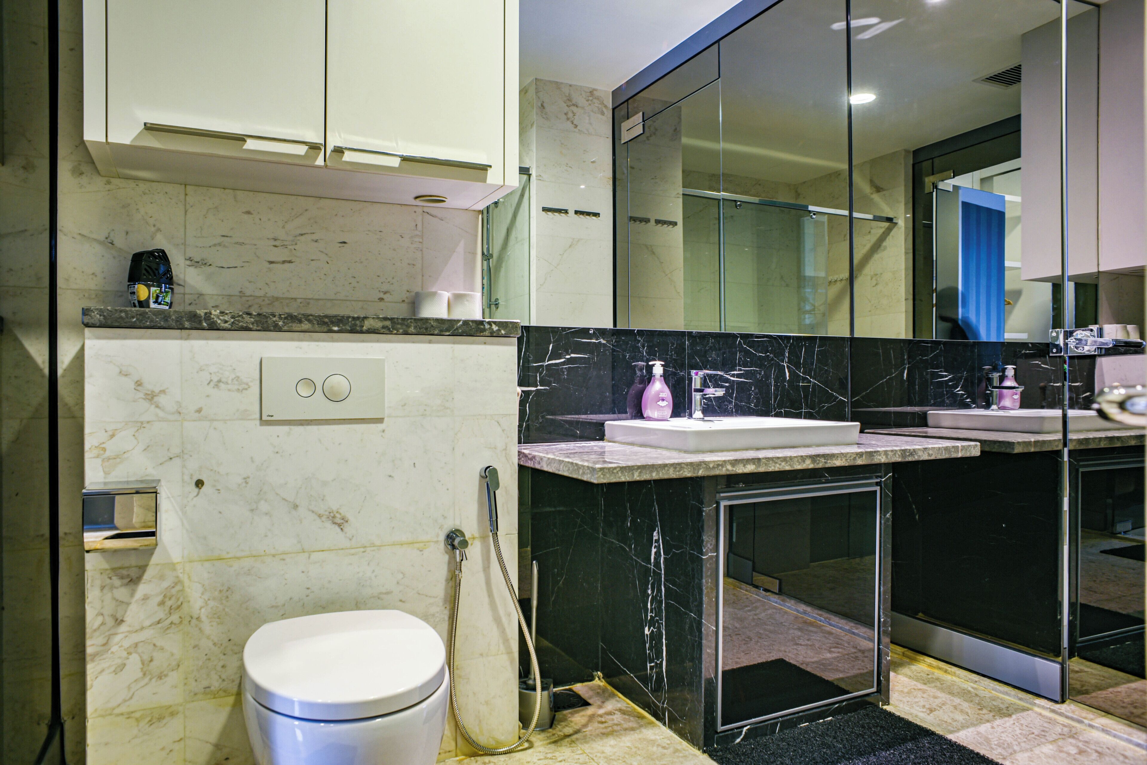 Un baño moderno con inodoro, lavamanos y ducha.