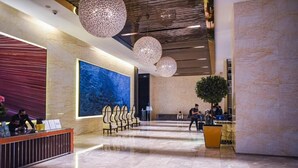 A spacious lobby with a reception desk, seating area, and a large abstract painting on the wall. - kl city center klcc by dome (Kuala Lumpur)