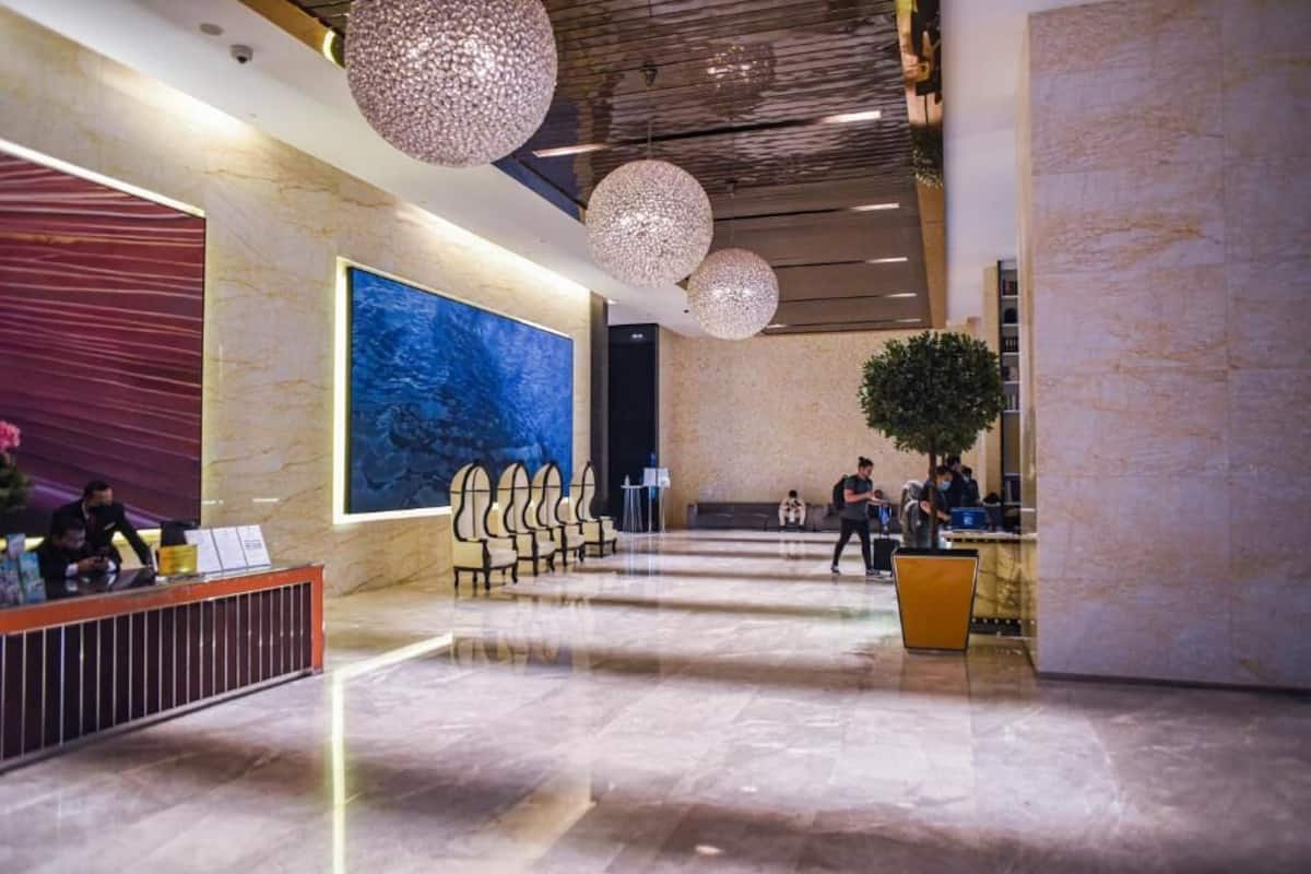 A spacious lobby with a reception desk, seating area, and a large abstract painting on the wall.