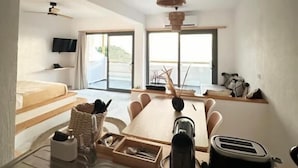 Una habitación moderna con comedor, lavamanos y vistas al mar.
