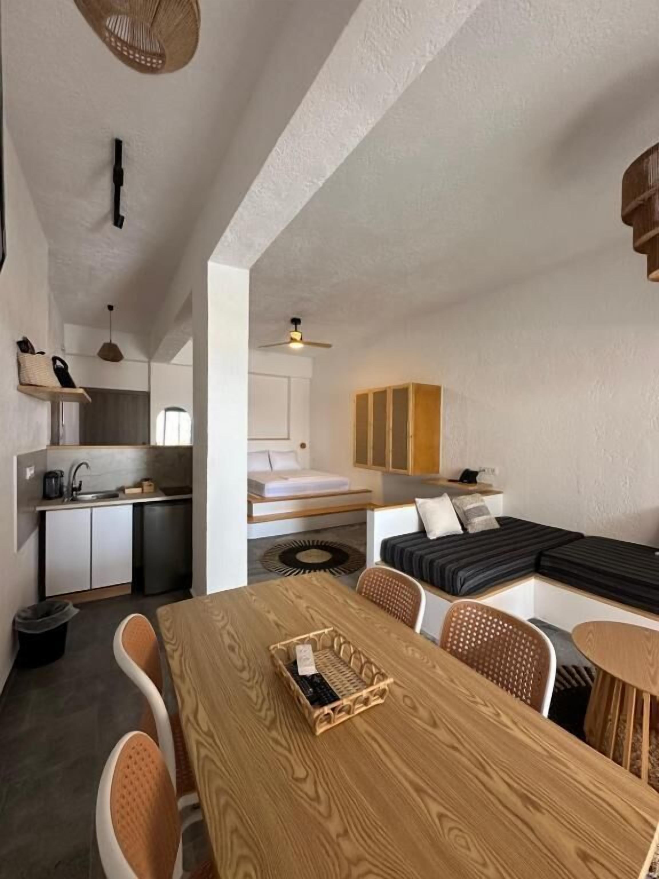 Ein gemütlicher Wohnbereich mit Essplatz, Küchenzeile und Bett.