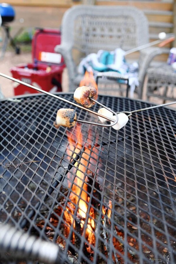 A grill with two marshmallows being roasted over an open flame.
