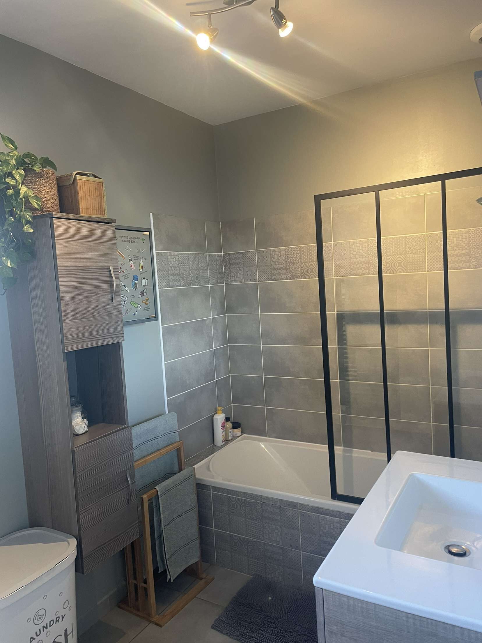 A modern bathroom with a large bathtub, a glass shower enclosure, and a built-in vanity with a mirror.