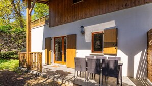 A wooden exterior with a covered patio, a sliding glass door, and a small window. - Apartment in Lacanau Near Beach (Lacanau)