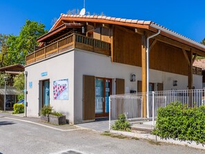 A two-story building with a reception desk, a wooden balcony, and a fenced outdoor area. - Apartment in Lacanau Near Beach (Lacanau)