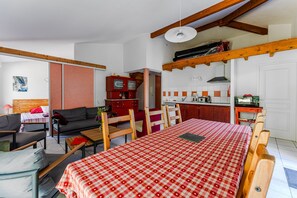 Una habitación con mantel a cuadros, sofá, cama y kitchenette.