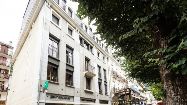 Un edificio a più piani con un locale commerciale al piano terra, tra cui una banca e un bar.