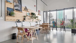 Um espaço de trabalho moderno com mesas, cadeiras e obras de arte nas paredes.