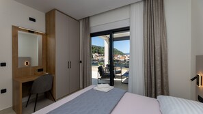 A hotel room with a bed, a desk, a chair, a large mirror, and a view of the outside. - Villa Sunset Blace by Villas Guide (Blace)